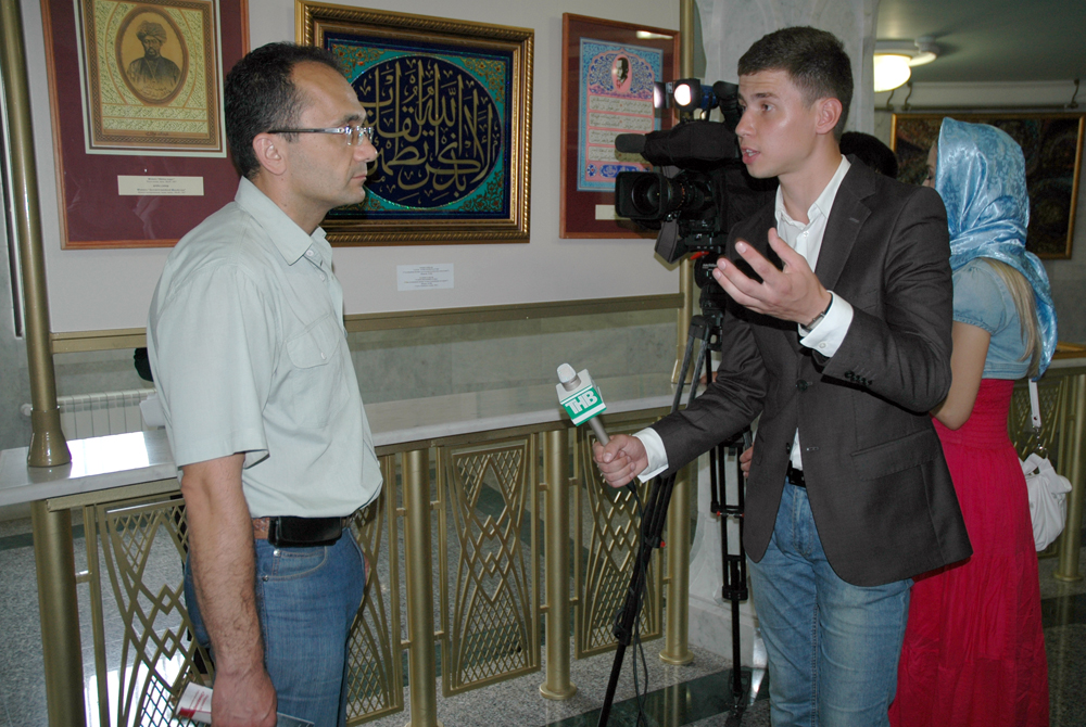 Журналист местного телевидения берет интервью на выставке шамаилей в Кул-Шарифе
