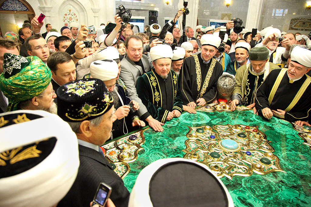 Имамы мечетей, муфтии и остальные гости стараются прикоснуться к огромному Корану